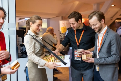 Gasten van een zakelijke bijeenkomst nemen broodjes aan van een Green Village medewerker die rondloopt met een plateau vol versnaperingen.